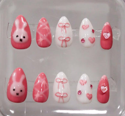 Set of pink and white nail art designs in a clear case.